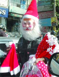 A street hawker dressed as Santa Claus sells caps and face masks ahead of the festival on December 25 in New Delhi
