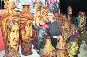 Two boys have a close look at terracotta pots at the Virasat festival in Dehradun
