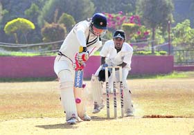 A batsman defends a delivery during a match in the 58th District Cricket League in Dehradun
