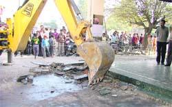 A JCB machine razes a structure at Sarabha Nagar in Ludhiana