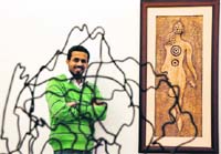 Harminder poses in front of his sculpture being displayed at Artmosphere