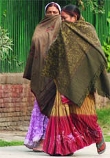 Women cover their faces as they brave the cold wind in New Delhi on Thursday morning.