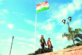 A couple walks past the National Flag installed on the banks of the Brahmasarovar in Kurukshetra