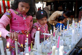 Tiny tots join the celebrations at the church by lighting candles