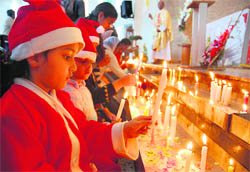 Children light candles on the occasion of Christmas at a church in Sector 19, Chandigarh, on Friday.