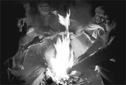 Rickshaw-pullers gather around a bonfire to beat the chill in Chandigarh on Friday.