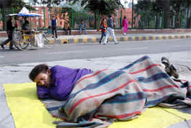A street dweller wraps himself in a blanket to escape the cold in New Delhi on Friday. 
