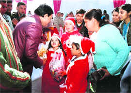 Uttarakhand Chief Minister Ramesh Pokhriyal Nishank being greeted by children dressed as Santa Claus at a function in Dehradun on Friday.