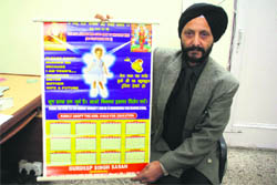 Gurdeep Singh Sasan, chairman of the J&K Childrens Welfare Society, shows a New Year calendar with a message against foeticide in Jammu.