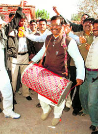 Former Jharkhand Chief Minister and JVM chief Babu Lal Marandi beats a drum during a rally in Ranchi on Friday