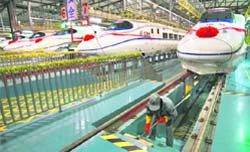 A labourer beside a China Railway high-speed train preparing for the operation ceremony from Wuhan to Guangzhou