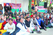 Congress workers sit on dharna at Gandhi Park in Dehradun on Saturday. 