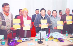 Chief Minister Ramesh Pokhriyal Nishank releases the annual report of the Aromatic Plant Centre at Selaqui near Dehradun on Saturday. 