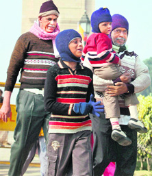 Members of a family shield themselves from cold as they take a walk near the India Gate in New Delhi.