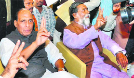 Former BJP chief Rajnath Singh and JMM supremo Shibu Soren flash a victory sign at a press conference in Ranchi on Saturday.