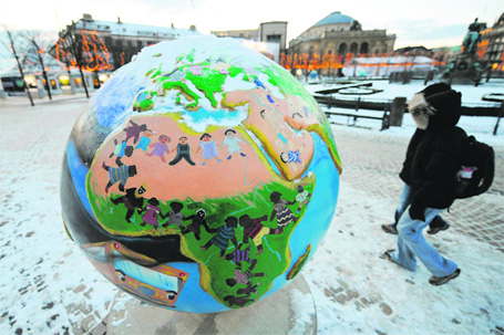 People walk past a globe — part of a “Cool Globe” exhibition — symbolising the fight against global warming and climate change in Copenhagen.