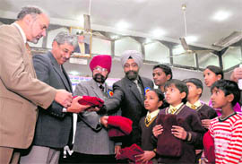 Sweaters being distributed among poor students at the installation ceremony of the Doon Sikh Welfare Society in Dehradun on Sunday