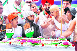 Congress party workers cut a cake along with children on the occasion of the 125th anniversary of the party, in Thane on Sunday