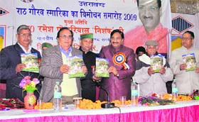 Uttarakhand Chief Minister Ramesh Pokhriyal Nishank (centre) releases the souvenir of the Rath Gaurav Samarika at a function in Dehradun