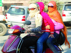 Amritsar girls go on a scooter covering themselves with shawls and sweaters to ward off cold. 