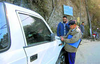 A police officer challans a vehicle for wrong parking at Lakkar Bazaar in Shimla
