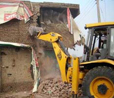 Demolition drive being carried out on Mansa road in Bathinda on Wednesday.
