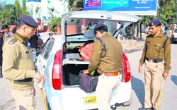Policemen search a car during a special drive in Dehradun