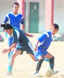 Players vie for the ball during a match in the Khadag Bahadur Memorial Football Tournament in Dehradun