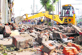 An illegal structure being razed near the Jalandhar bypass in Ludhiana on Wednesday.