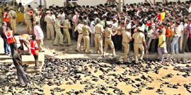 Police tries to disperse the crowd gathered to pay tributes to Kannada actor Vishnuvardhan, as hundreds of slippers are seen lying in the foreground, in Bangalore on Wednesday