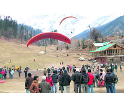 Tourists watching paragliding at Solang.