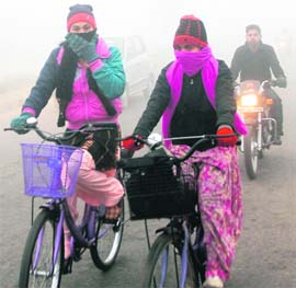 Braving cold weather, a woman cycles her way to work in Jalandhar