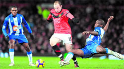 Manchester Uniteds Wayne Rooney (R) vies with Charles NZogbia at Old Trafford on Thursday