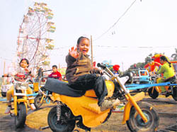 Children enjoy a ride on toy motorcycles during the winter fair at Sector 34, Chandigarh.