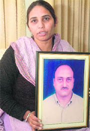 Paramjit Kaur, wife of Manmohan Singh Mohni, shows her husbands photograph in Chandigarh.
