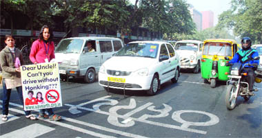 Volunteers of the Earth Saviours Foundation hold hoardings at Janpath, near McDonalds restaurant, in New Delhi to educate drivers to stop unnecessary honking while driving on Friday. 