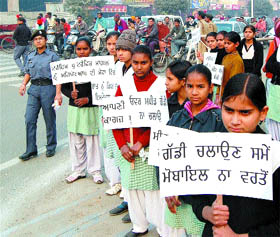Schoolchildren hold placards carrying slogans to spread awarness among people about traffic rules in Amritsar. 