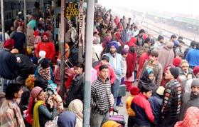 People wait for trains, which were delayed due to tripping of northern grid as a result of heavy fog, at the Jalandhar railway station