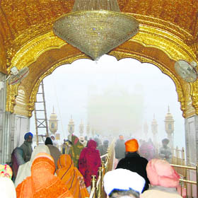 A view of the Golden Temple covered in dense fog due to cold conditions in Amritsar on Saturday.