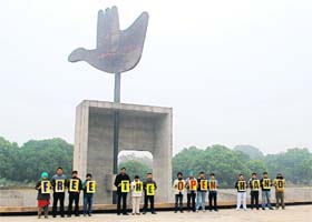 A group of local residents hold placards at the Open Hand Monument in Chandigarh