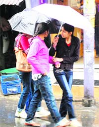 Girls caught unaware in a drizzle at Kotwali bazaar in Dharamsala