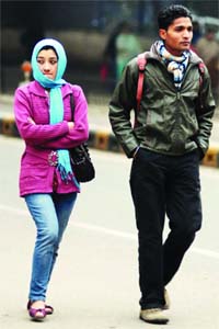 A couple cover themselves with warm clothes as they take a walk in the chilly weather in New Delhi