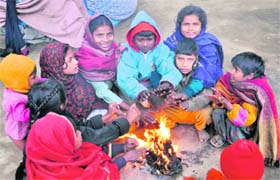 Poor children huddle around a bonfire