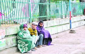 Labourers trying to ward off cold by huddling together at the Gandhi Park in Dehradun