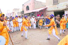 Youngsters play gatka during a nagar kirtan in Sirsa