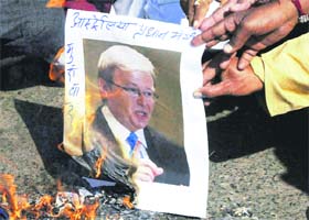 BJP activists burn a photograph of Australian PM Kevin Rudd during a protest in Bhopal
