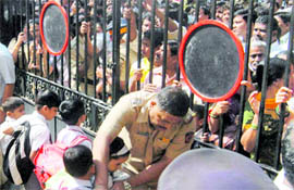 Parents wait for their children outside Shardashram High School after a student committed suicide in Mumbai on Monday.