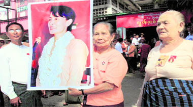 A supporter of the National League for Democracy holds a portrait of their detained leader Aung San Suu Kyi outside the party headquarters to mark the 62th anniversary of Independence Day in Yangon on Monday.
