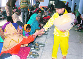 A child distributes langar on the occasion of Guru Gobind Singh’s birth anniversary in Mohali on Tuesday.