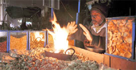 A groundnut-seller tries to warm himself in Dehradun on Tuesday.